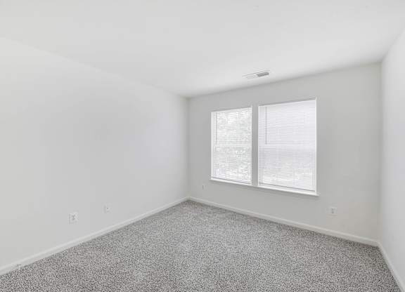 Empty bedroom with carpet and window at Acclaim at Ashburn Apartments, Virginia