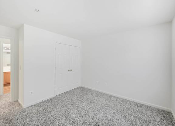 Empty bedroom with gray carpet and closet at Acclaim at Ashburn Apartments, Virginia, 20147