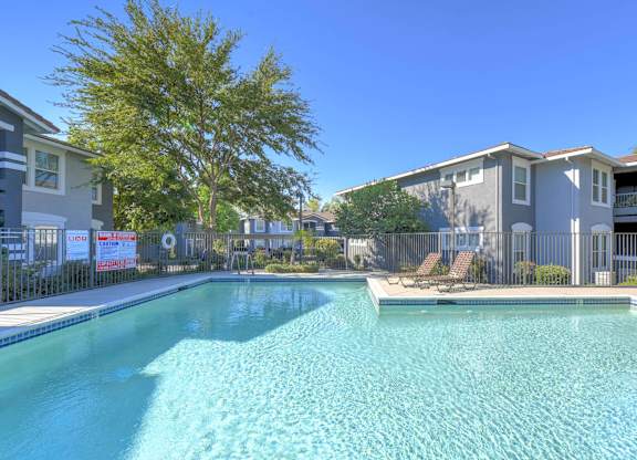 A swimming pool in front of apartment buildings.