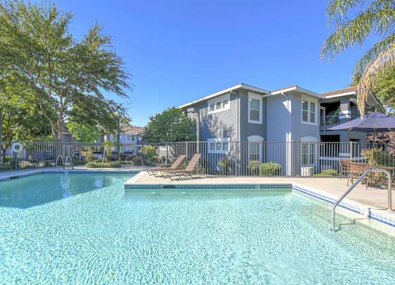 A swimming pool in front of a residential building.