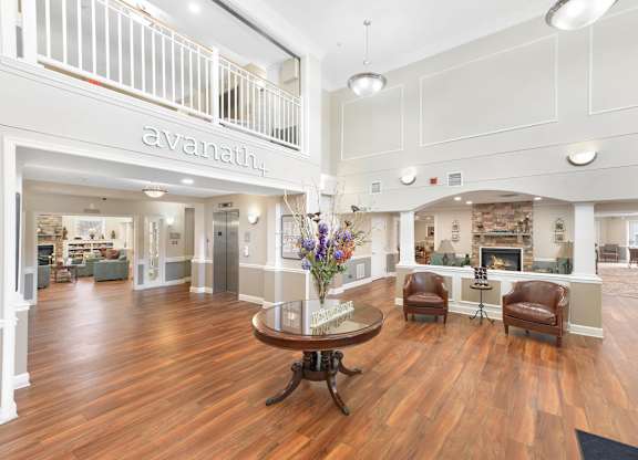 A large room with a wooden floor and a table in the middle.