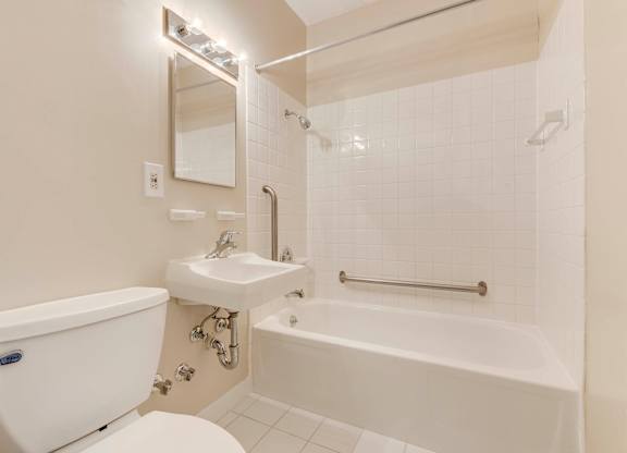 A white bathroom with a tub, sink, and toilet at Menlo Manor Apartments, New Jersey, 08820