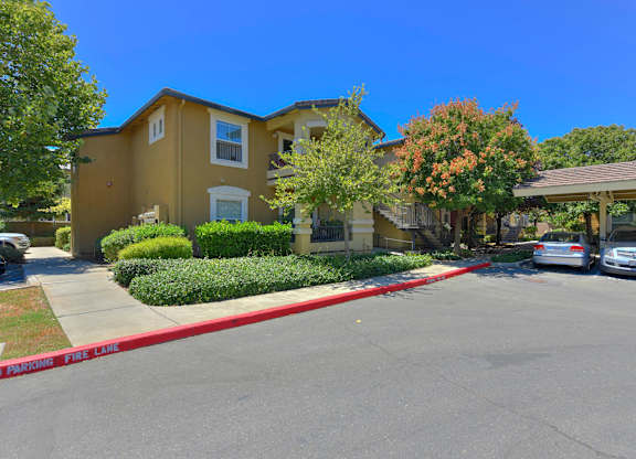 A sunny day at a residential area with cars parked in front of houses at Hurley Creek Apartment Homes, California, 95834