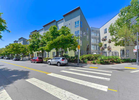 Street view with cars at Crescent Cove Apartments, California