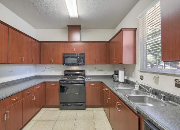 A kitchen with brown cabinets and a black stove top oven.