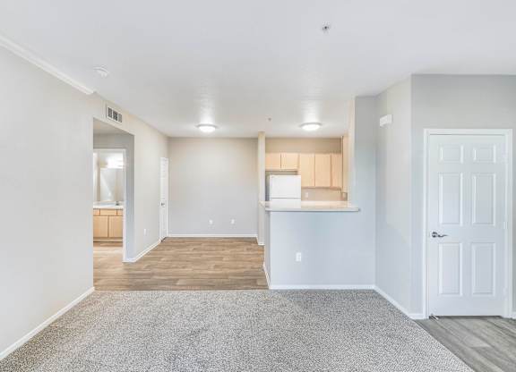 A spacious room with a carpeted floor and white walls.