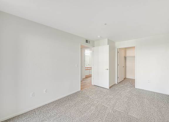 A room with white walls and a grey carpet.
