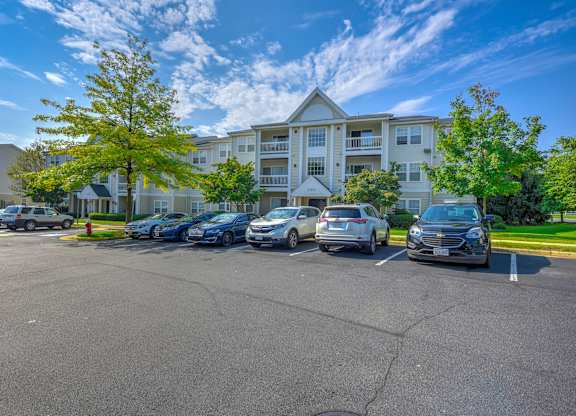 Parking lot with cars and apartment buildings at Acclaim at Ashburn Apartments, Virginia