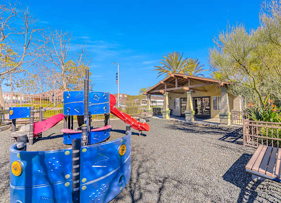 A playground with a blue slide and a wooden bench at Yorba Linda Apartments, Yorba Linda California