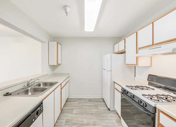 A kitchen with white appliances and a white refrigerator.