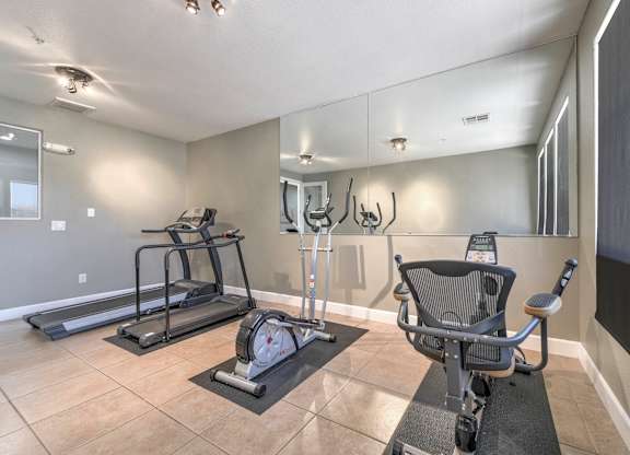A gym with a treadmill, elliptical trainer and a stationary bike at Hurley Creek Apartment Homes, California, 95834