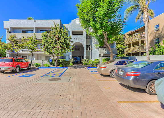 A parking lot with cars and a building in the background.