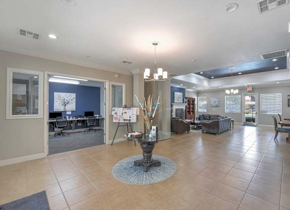 A spacious living room with a central fireplace and a dining area in the background at Hurley Creek Apartment Homes, Sacramento, California