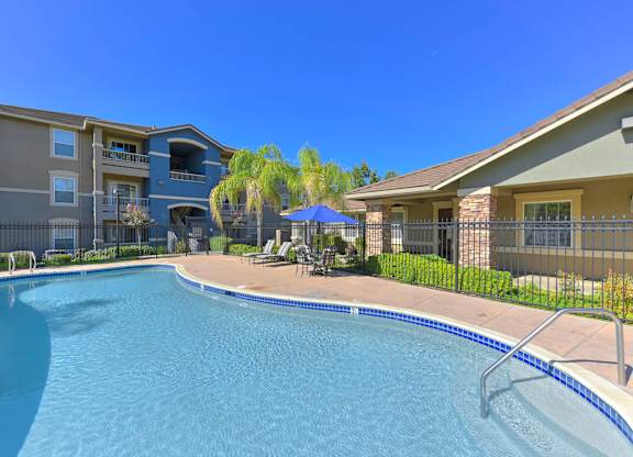 A swimming pool in front of apartment buildings.