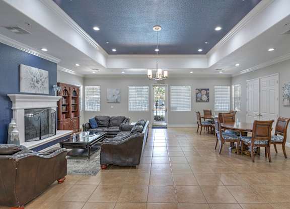 A living room with a fireplace and a dining table set up at Hurley Creek Apartment Homes, Sacramento, 95834