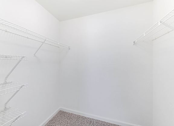 Empty walk-in closet with white walls and shelves at Acclaim at Sterling in Sterling, 20164