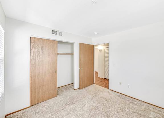 A room with a carpeted floor and two doors.