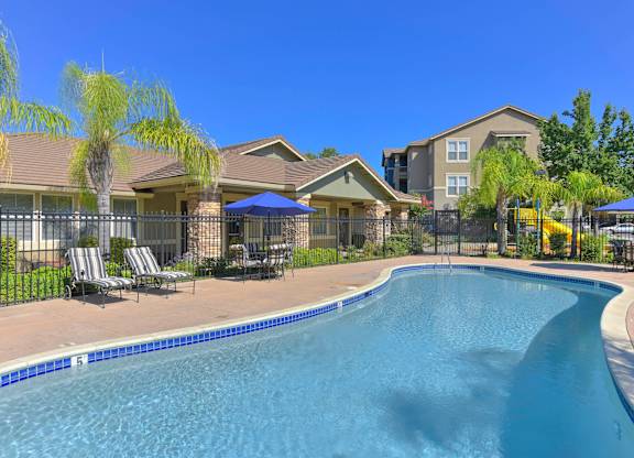 A swimming pool in front of apartment buildings.