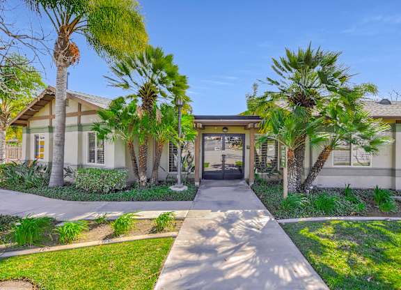 A building with a clear blue sky above it and palm trees in front at Yorba Linda Apartments, Yorba Linda, 92886