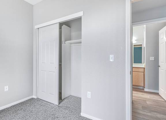 A white door is open to a room with a wooden floor.
