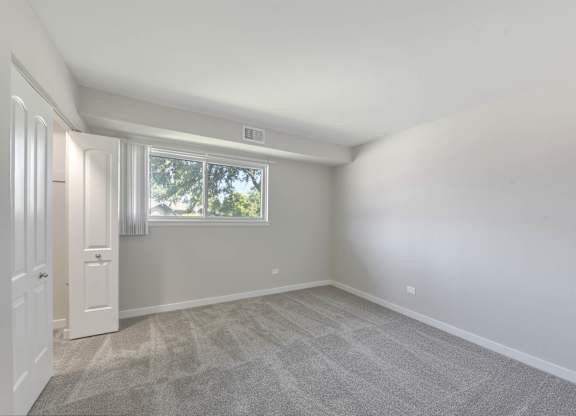 A room with a carpeted floor and a window. at Acclaim at Hinsdale Lake, Illinois