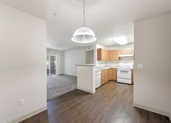 A kitchen with white appliances and wooden cabinets at Hurley Creek Apartment Homes, Sacramento, CA
