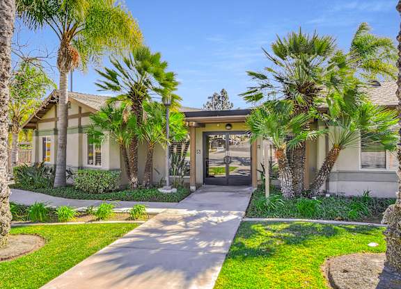 A house with a white fence and a green lawn at Yorba Linda Apartments, Yorba Linda
