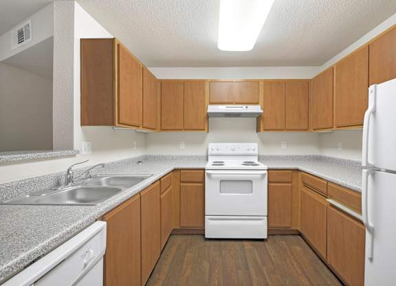 A kitchen with wooden cabinets and a white refrigerator at Hurley Creek Apartment Homes, Sacramento