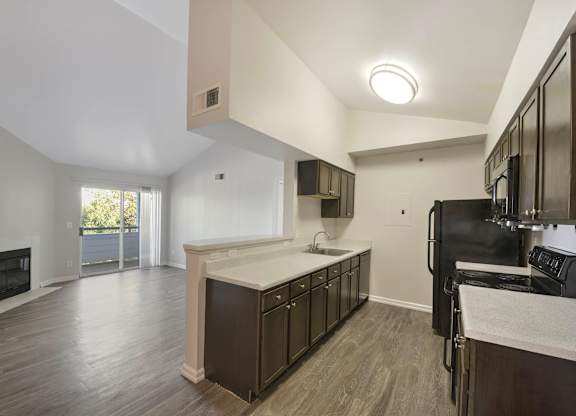 A modern kitchen with dark wood floors and stainless steel appliances. at Ascent, Denver, Colorado