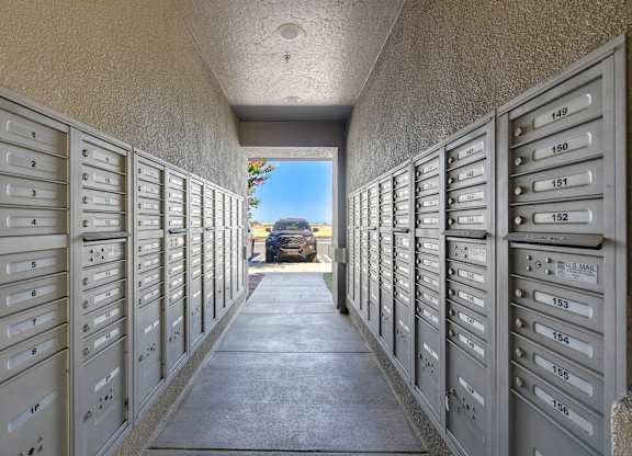 A long corridor of grey mailboxes with numbers on them.