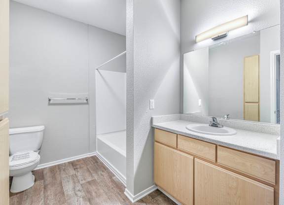 A white bathroom with a toilet, sink, and mirror.