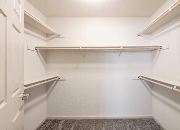 A white closet with three shelves and a carpeted floor at Hurley Creek Apartment Homes, California