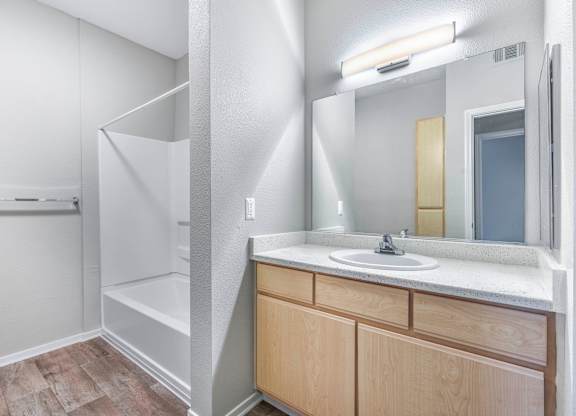 A bathroom with a sink, mirror, and a white door.