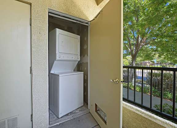 A white refrigerator and freezer are installed in a small outdoor space at Hurley Creek Apartment Homes, Sacramento, California