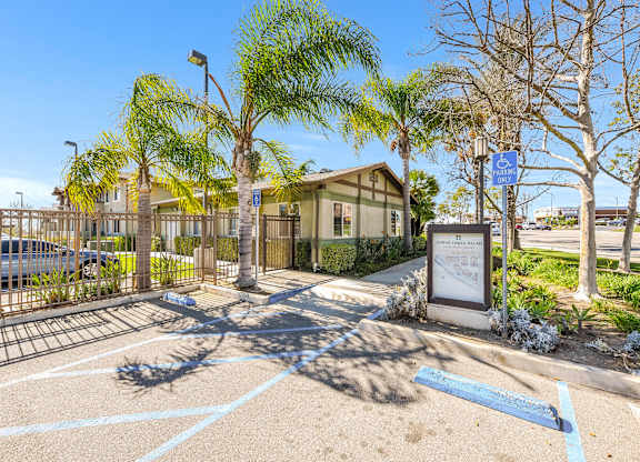 A parking lot with a sign and a building in the background at Yorba Linda Apartments, Yorba Linda, CA 92886