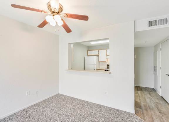 A room with a ceiling fan and a mirror on the wall.
