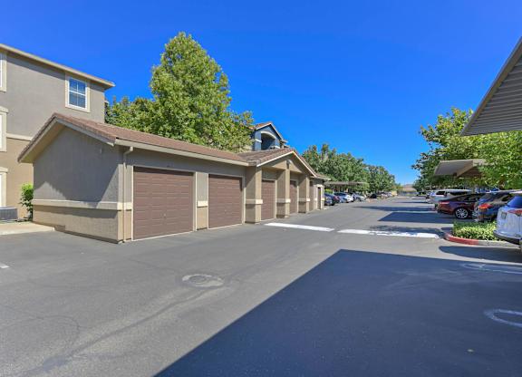 A sunny day in a residential area with houses and parked cars.