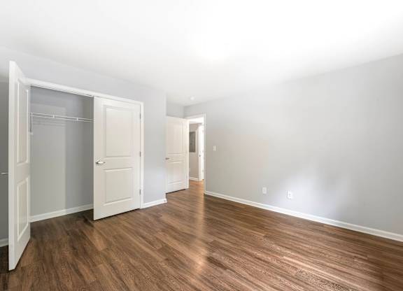 A room with a wooden floor and white walls. at Arbors at Cary, Cary, NC, 27511