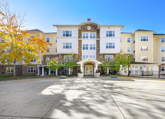 A large white building with a courtyard in front.