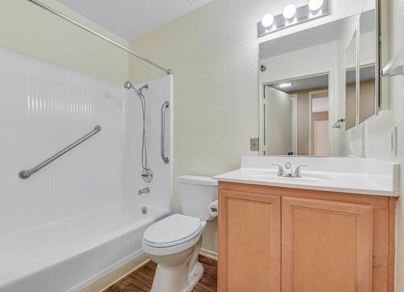 A white toilet sits next to a white bathtub in a bathroom.