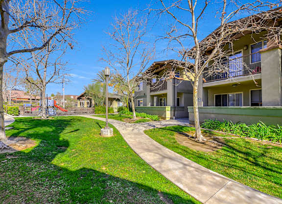 A sunny day at a residential area with apartment buildings and a playground at Yorba Linda Apartments, Yorba Linda, CA