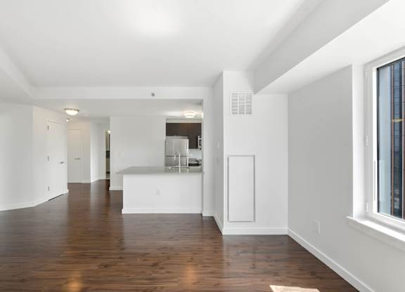 A long white hallway with wood floors and white walls. at 7 Dekalb, Brooklyn, NY