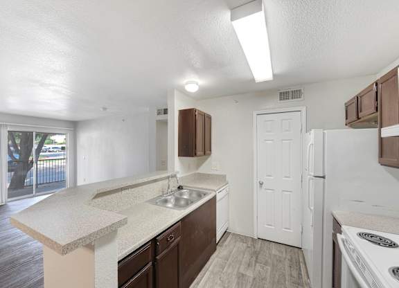 A kitchen with white cabinets and a white fridge. at Cooper's Crossing, Irving