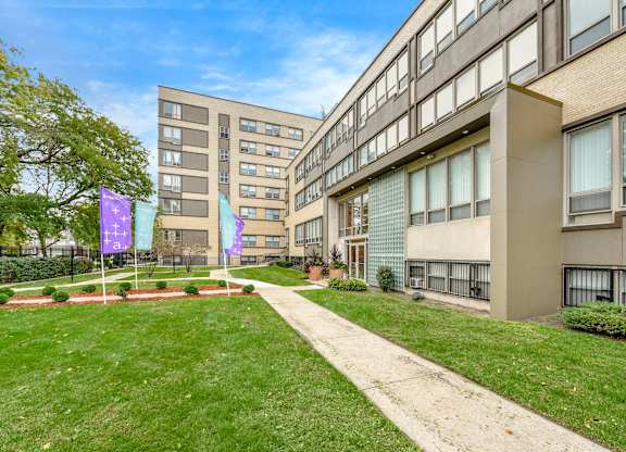 A building with a green lawn in front of it. at Academy at Drexel Apartments, Illinois