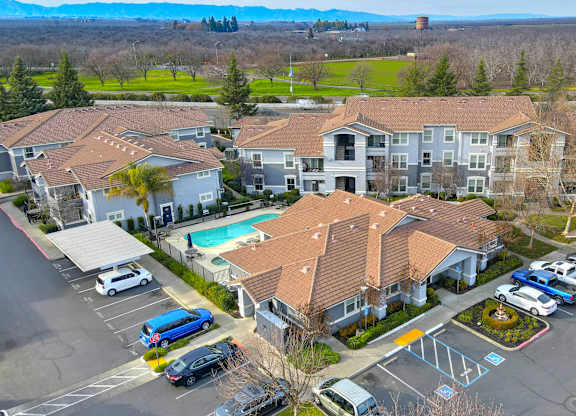 Aerial view of apartment buildings with pool and parking at Lincoln Creek Apartments, California, 95620