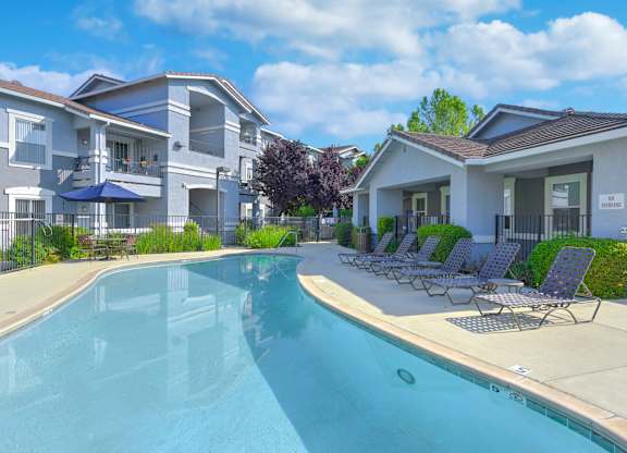 Swimming pool area with lounge chairs and shade at Lincoln Creek Apartments, Dixon, California