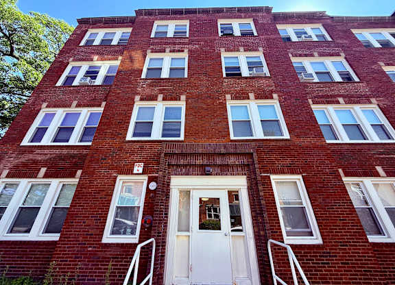 A red brick building with a white door and windows.