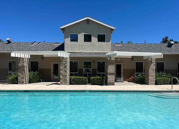 A large house with a pool in front.
