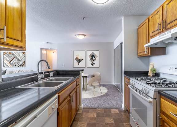 A kitchen with a black counter top and a white stove.at Retreat at Valencia Apartment Homes, Orlando