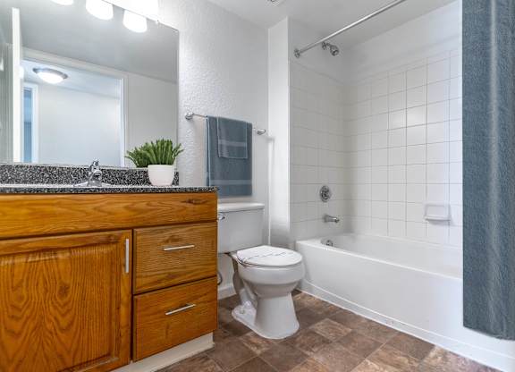 A bathroom with a toilet, sink, and bathtub at Retreat at Valencia Apartment Homes, Orlando, FL.